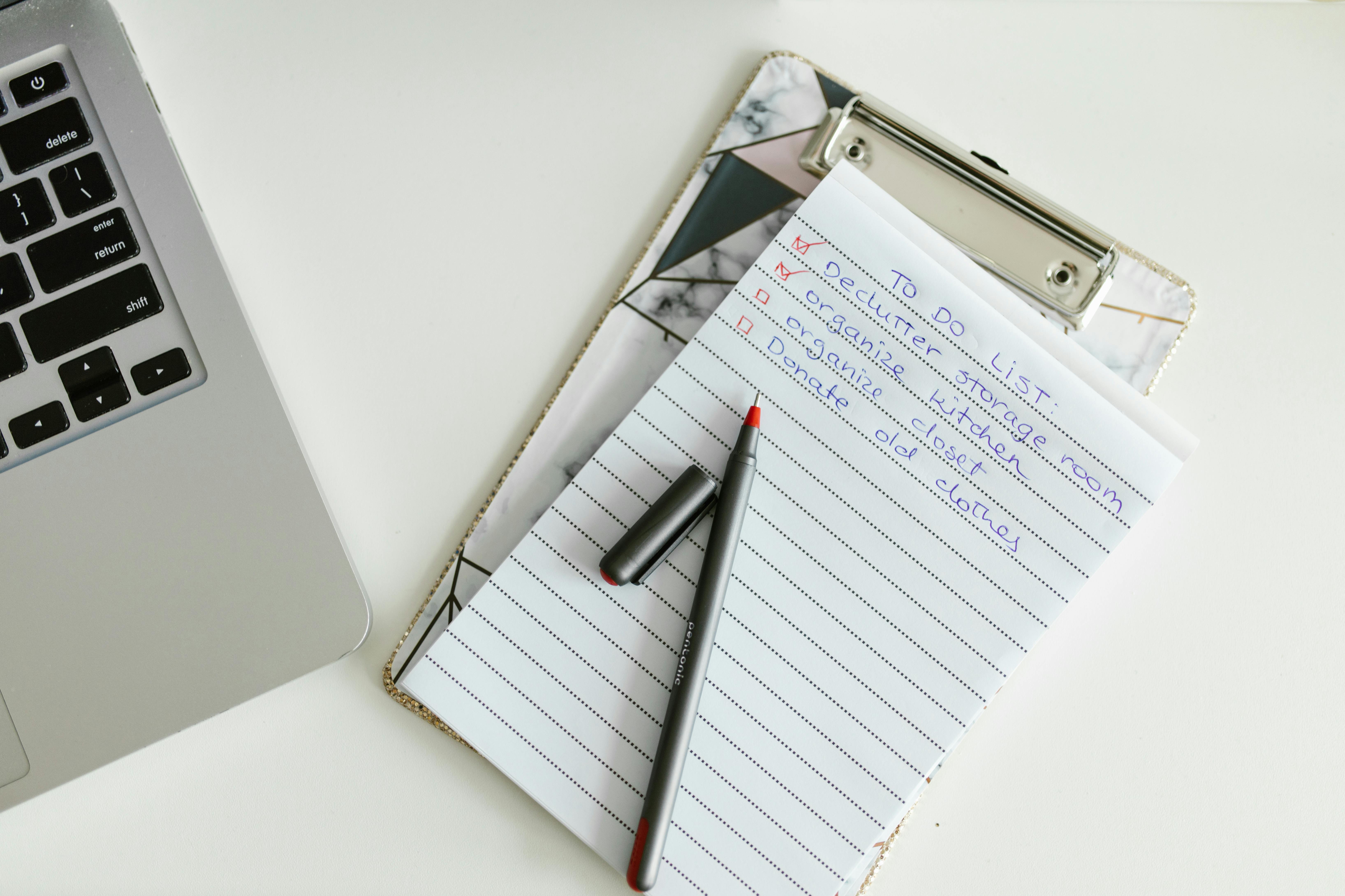 scientific poster printing checklist on a laptop beside a large format proof and a red pen