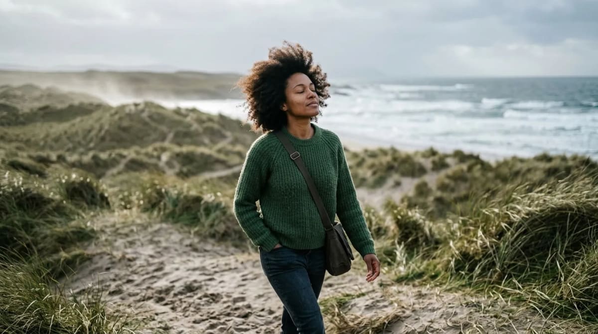 Traveler walking a windswept beach on an Ireland-focused Aer Lingus award trip