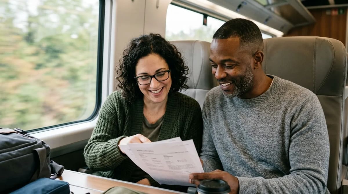 Travelers on a high-speed train reviewing Avios transfer mechanics and timing