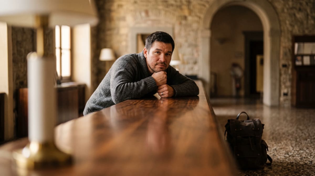 Traveler leaning on a concierge desk in Bergamo, seen along the desk