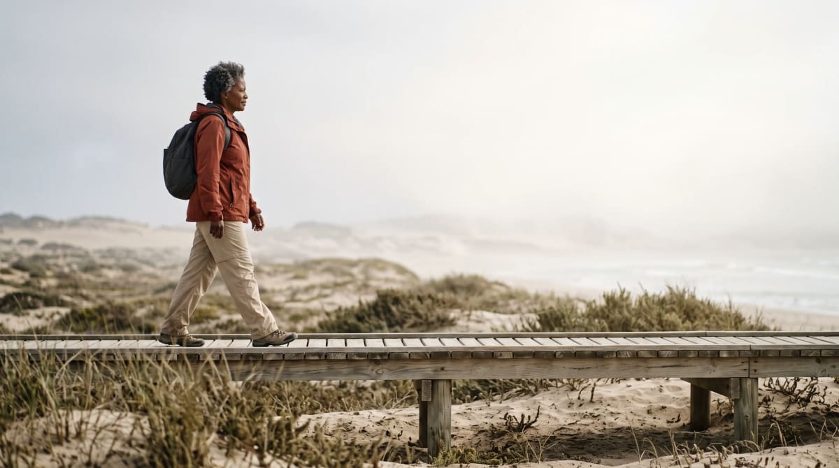 Traveler walking on a beach boardwalk in the morning with a backpack