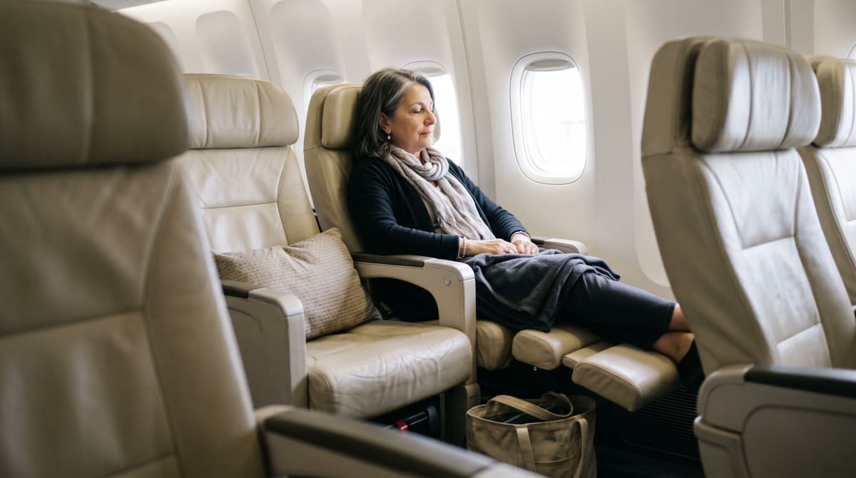 A traveler reclining in premium economy seat