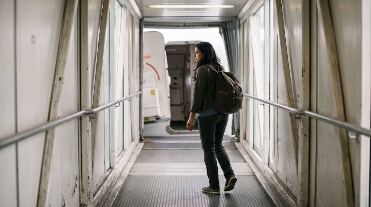 A traveler with a backpack on a Miami jet bridge