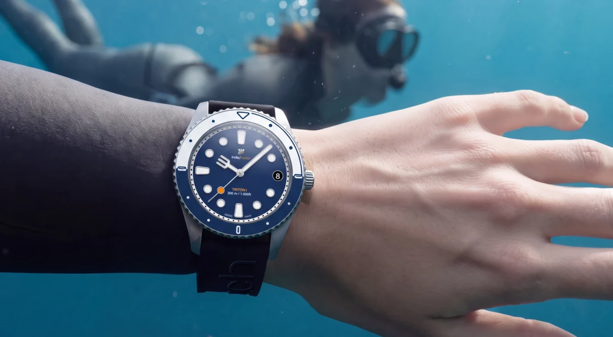 Bajo el agua, una buceadora y, en primer plano, una muñeca con el Tritón I Tabarca de esfera azul marino