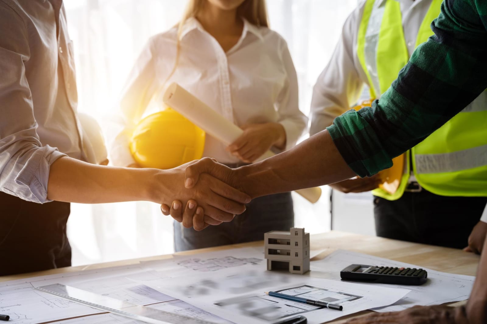 Contratistas y arquitectos dan la mano tras un acuerdo exitoso / Contractors and architects shaking hands after completing a project