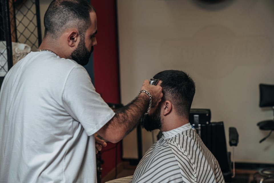 Peluquero atendiendo a un cliente en una barbería