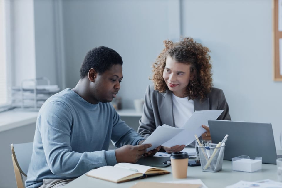 Two colleagues going over documents in a meeting