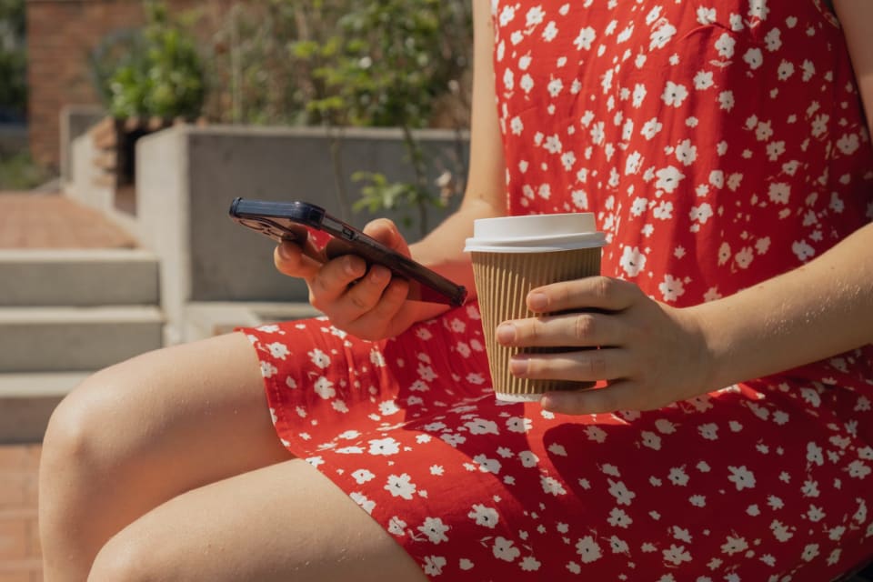 Woman scrolling social media on her phone on a bench