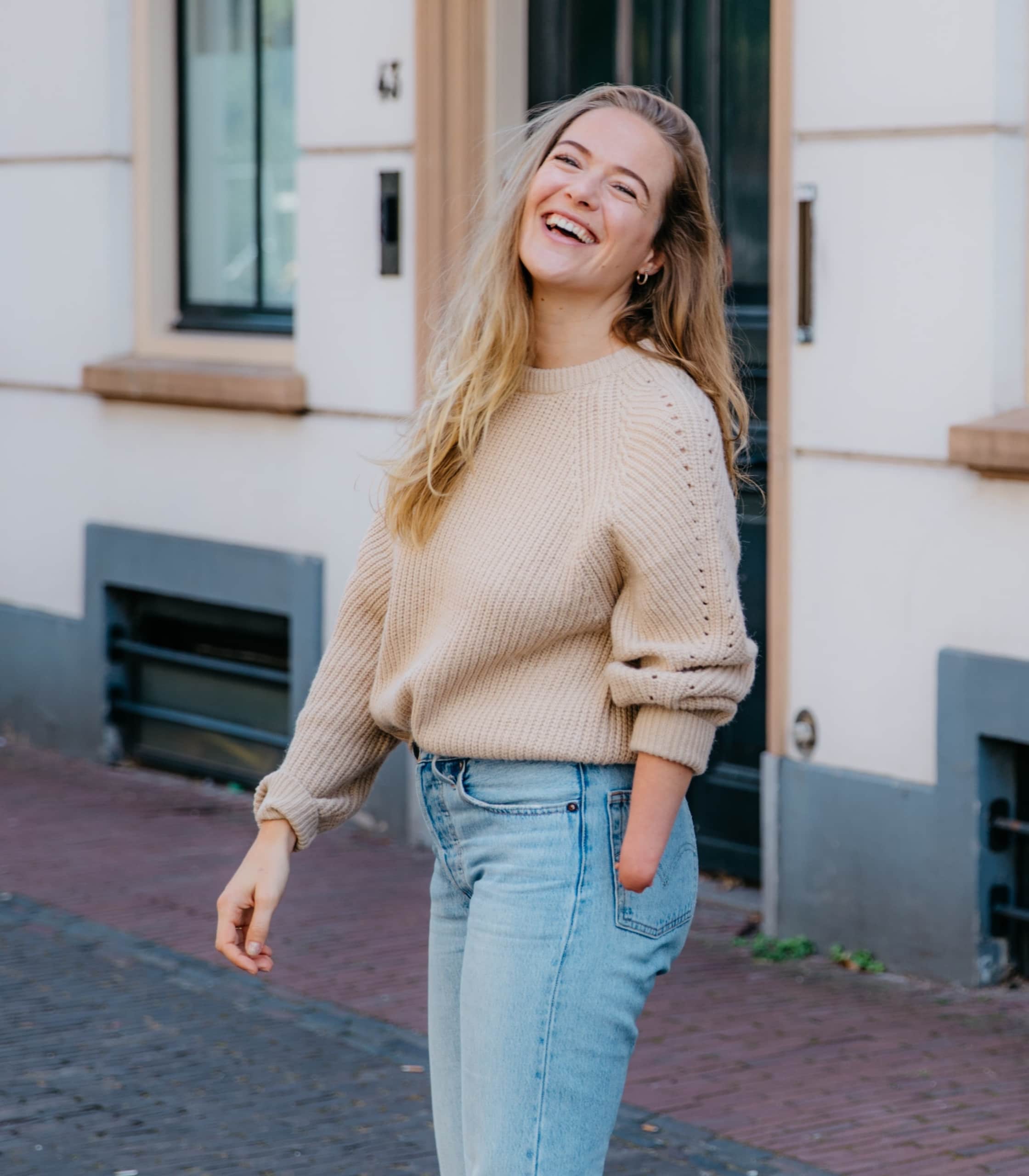 Formación en moda inclusiva. Imagen de una chica sonriendo en la calle con una amputación en el brazo.