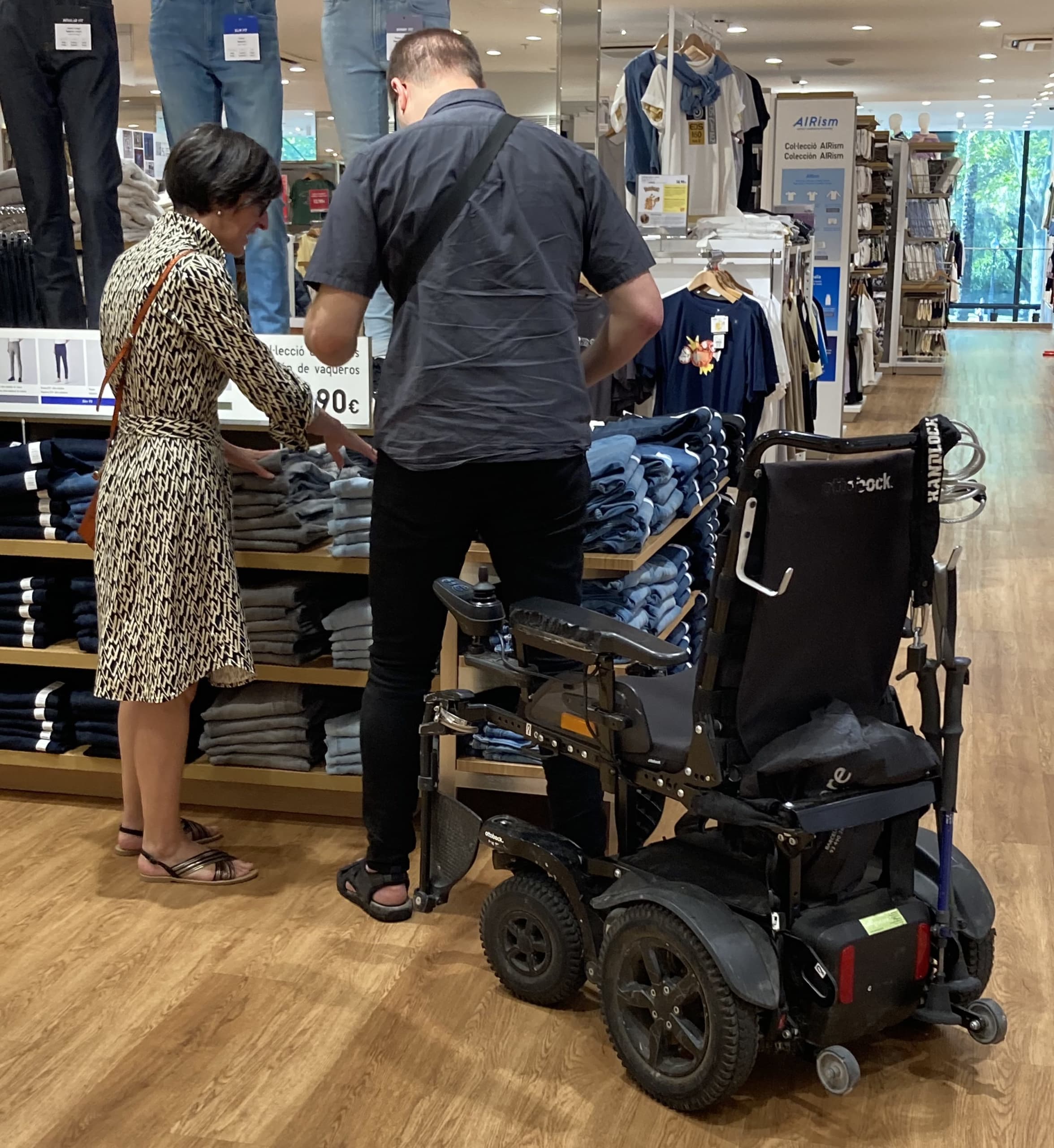 Consultoría especializada en asesoramiento y formación en accesibilidad y diseño inclusivo. Imagen de Robert y Rut en una tienda mirando ropa.