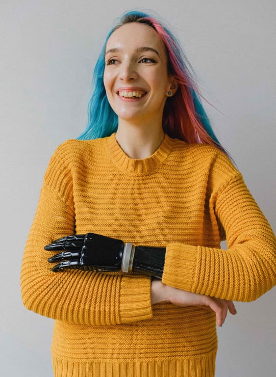 Consultoría y formación en moda inclusiva. Imagen de una chica sonriendo con su brazo biónico.