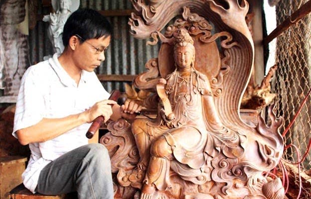 Nghệ nhân đang chạm khắc tượng Quan Âm bằng gỗ