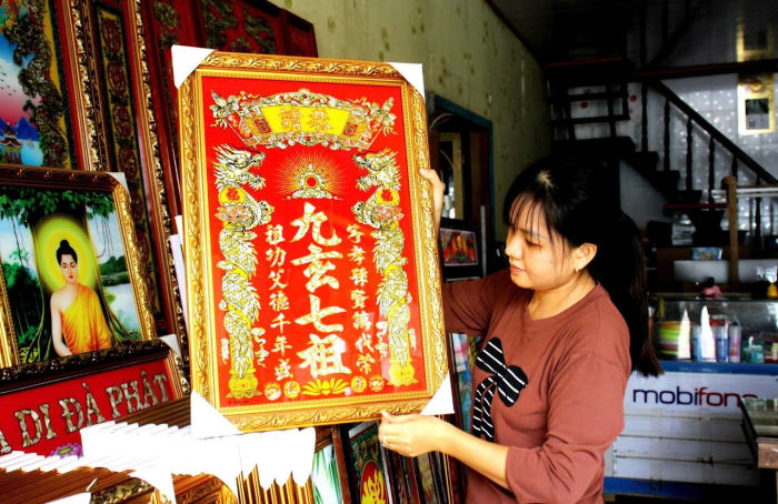 Người thợ nâng một bức tranh kiếng lớn màu đỏ