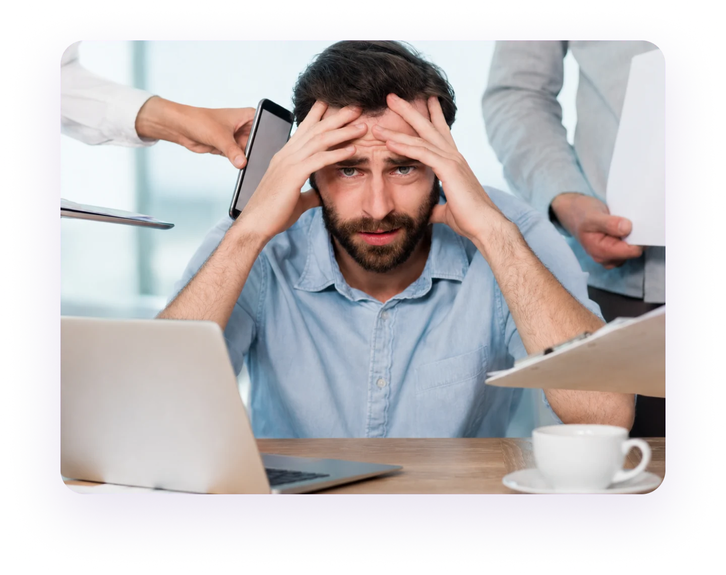 An overwhelmed office worker sitting at a desk