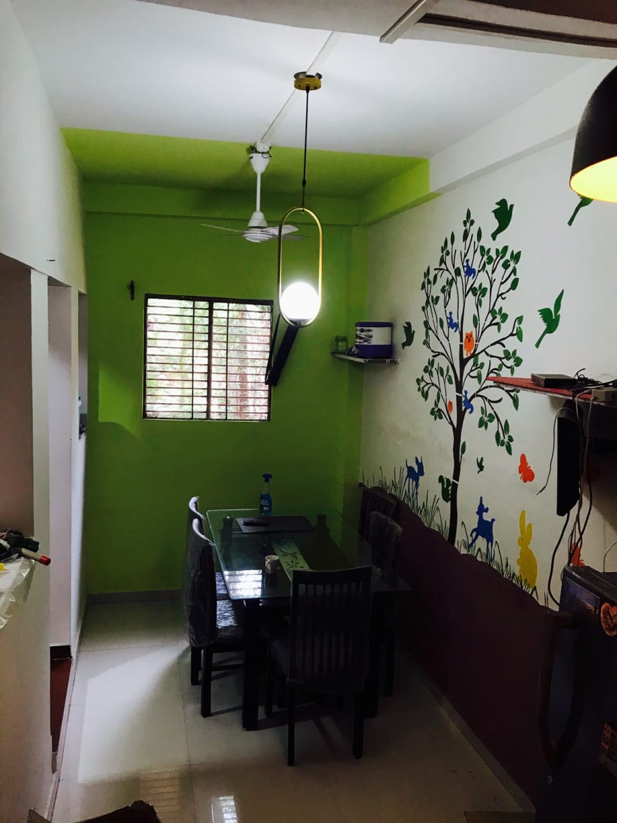 Dining room with lime green end wall, tree wall decal and pendant light