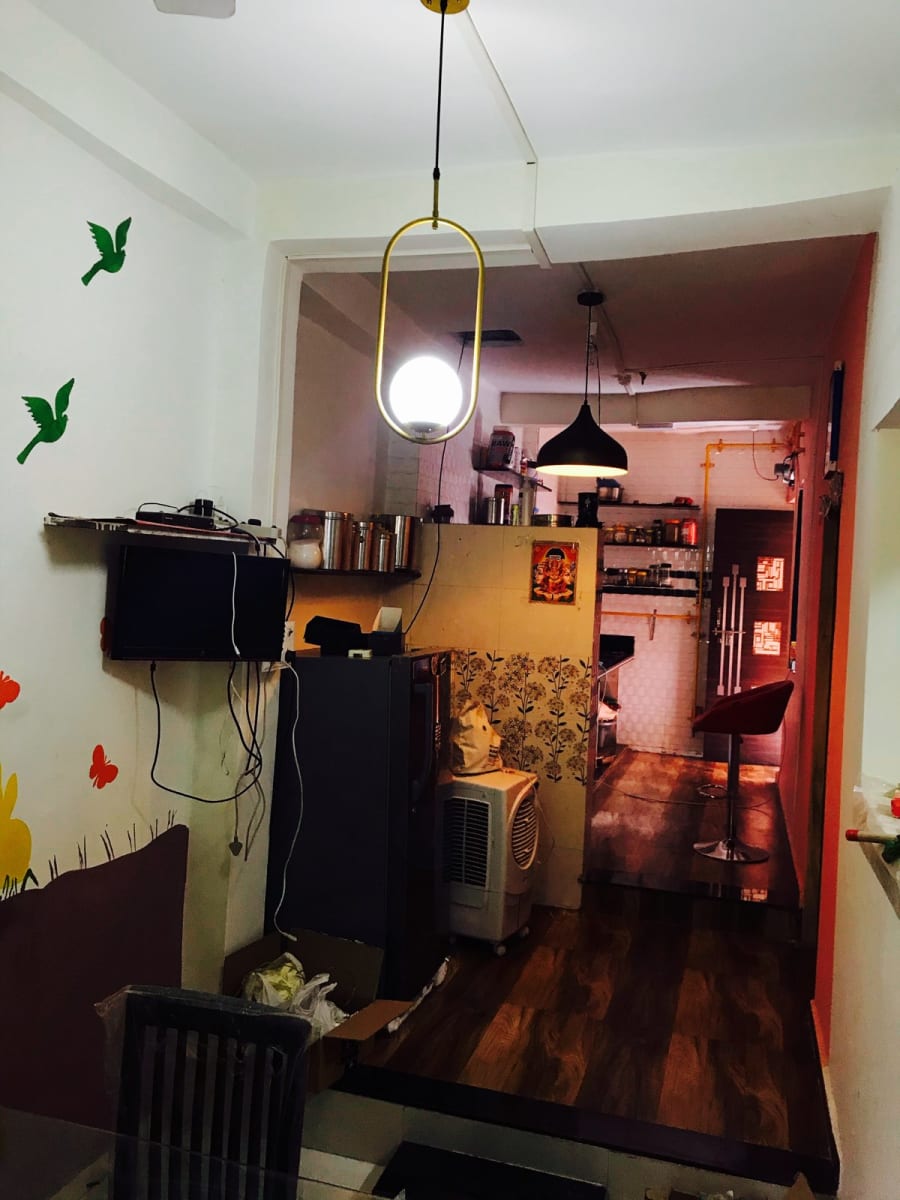 Hallway with bird wall decals and a brass pendant light, kitchen beyond