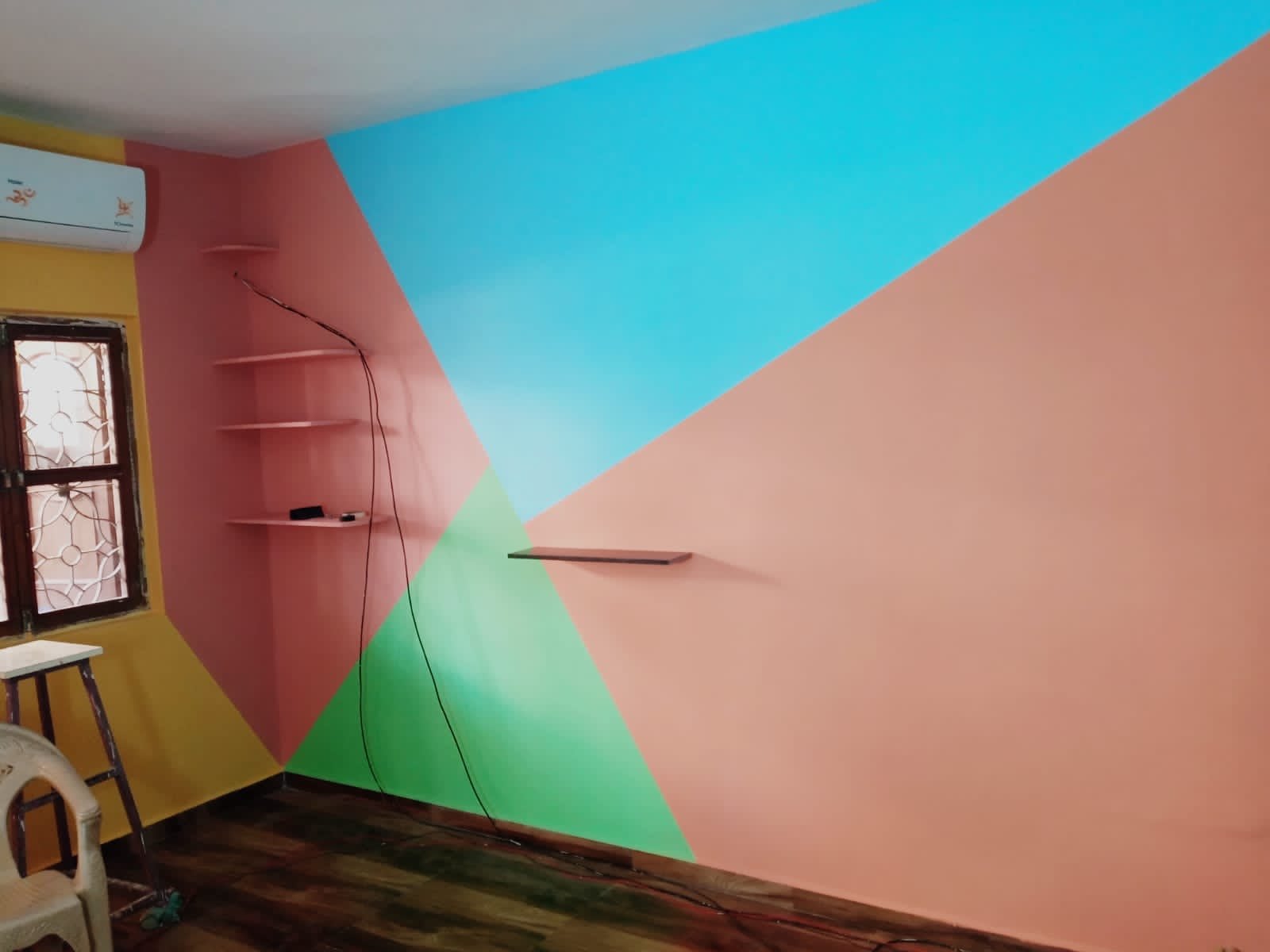 Freshly painted wall with pink, blue and green geometric colour blocks