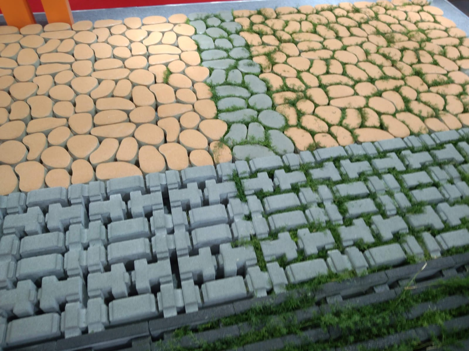 Interlocking concrete paver samples with grass growing through the gaps
