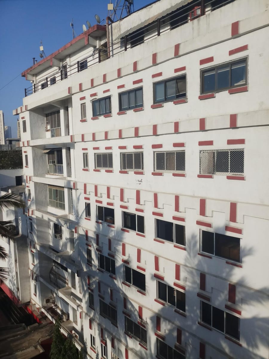 White multi-storey building facade with red rectangular accents around its windows