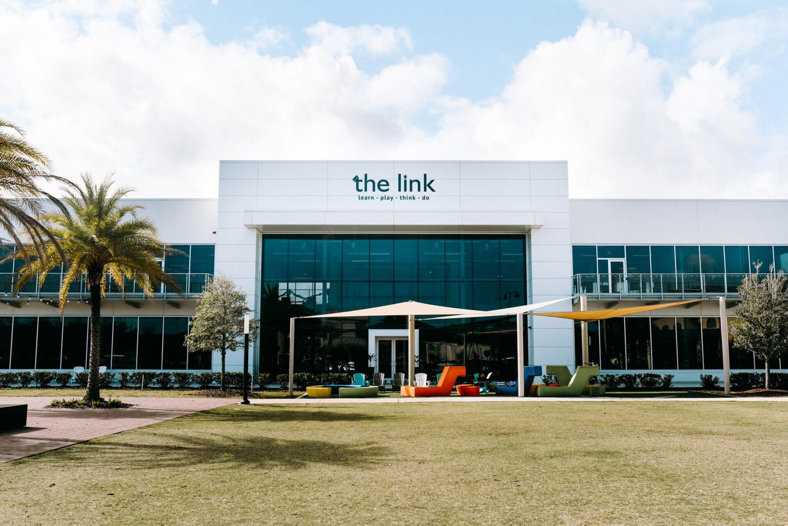 The Link at Nocatee: a white two-storey office building with a glazed entrance, shade sails and a lawn in front