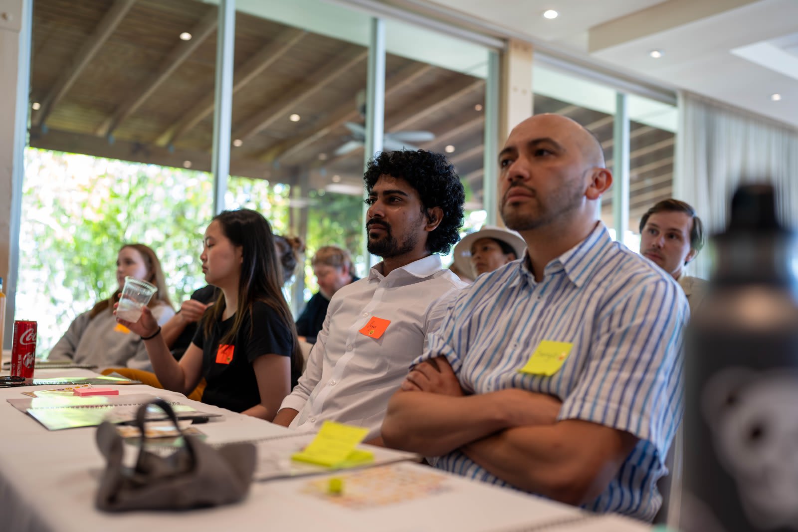 Team members seated at tables with sticky notes during a retreat session