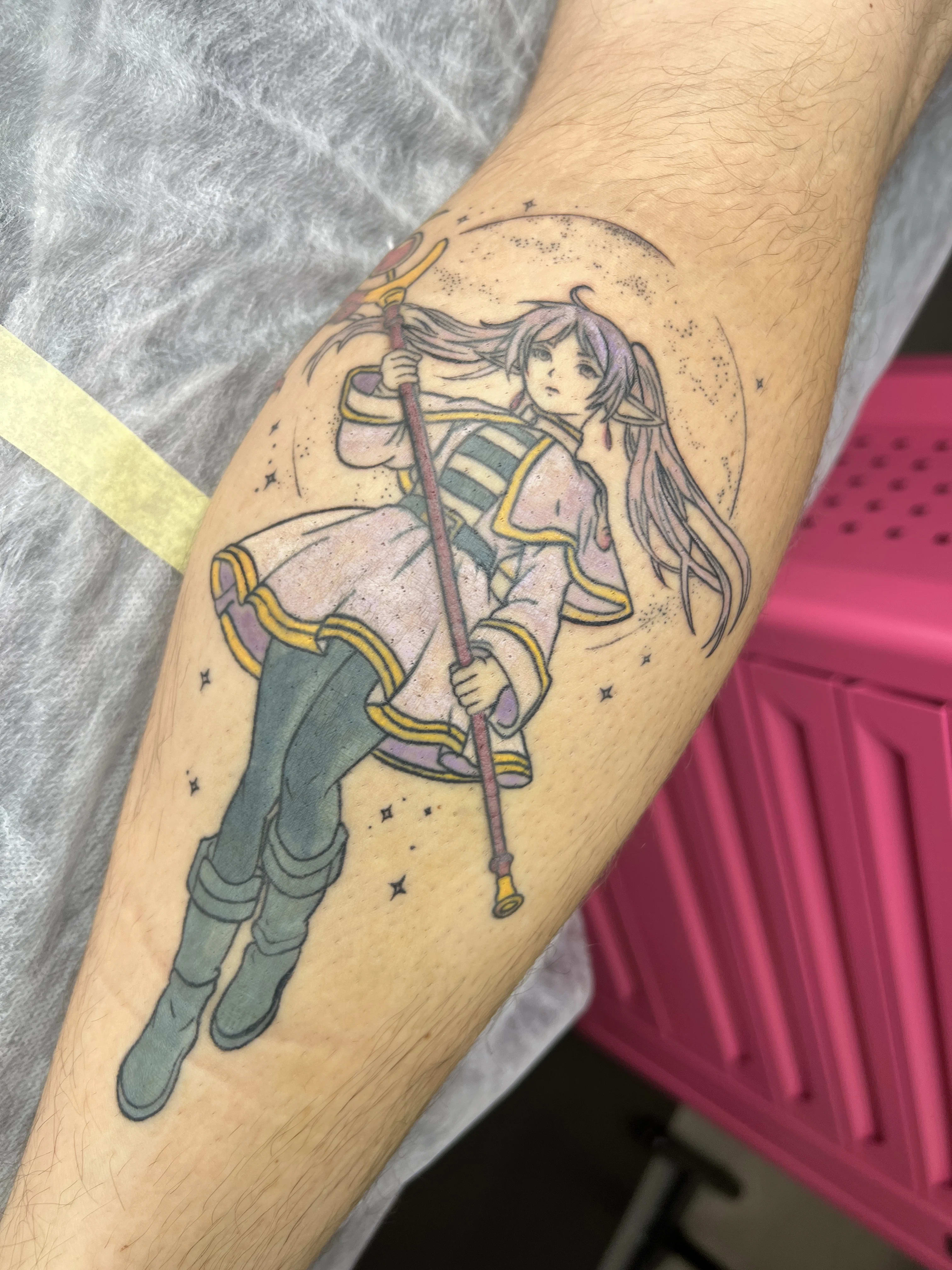 Tatuaż z postacią z anime trzymającą magiczną laskę w gwiezdnym kręgu