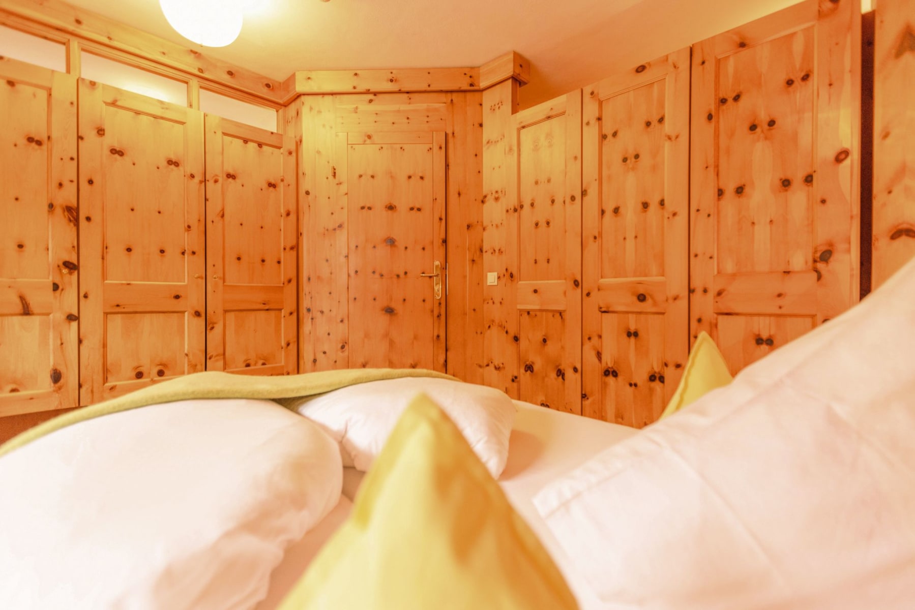 Ein gemütliches Zimmer im Glemmtalerhof in Hinterglemm mit Holzdetails und weichen Kissen.