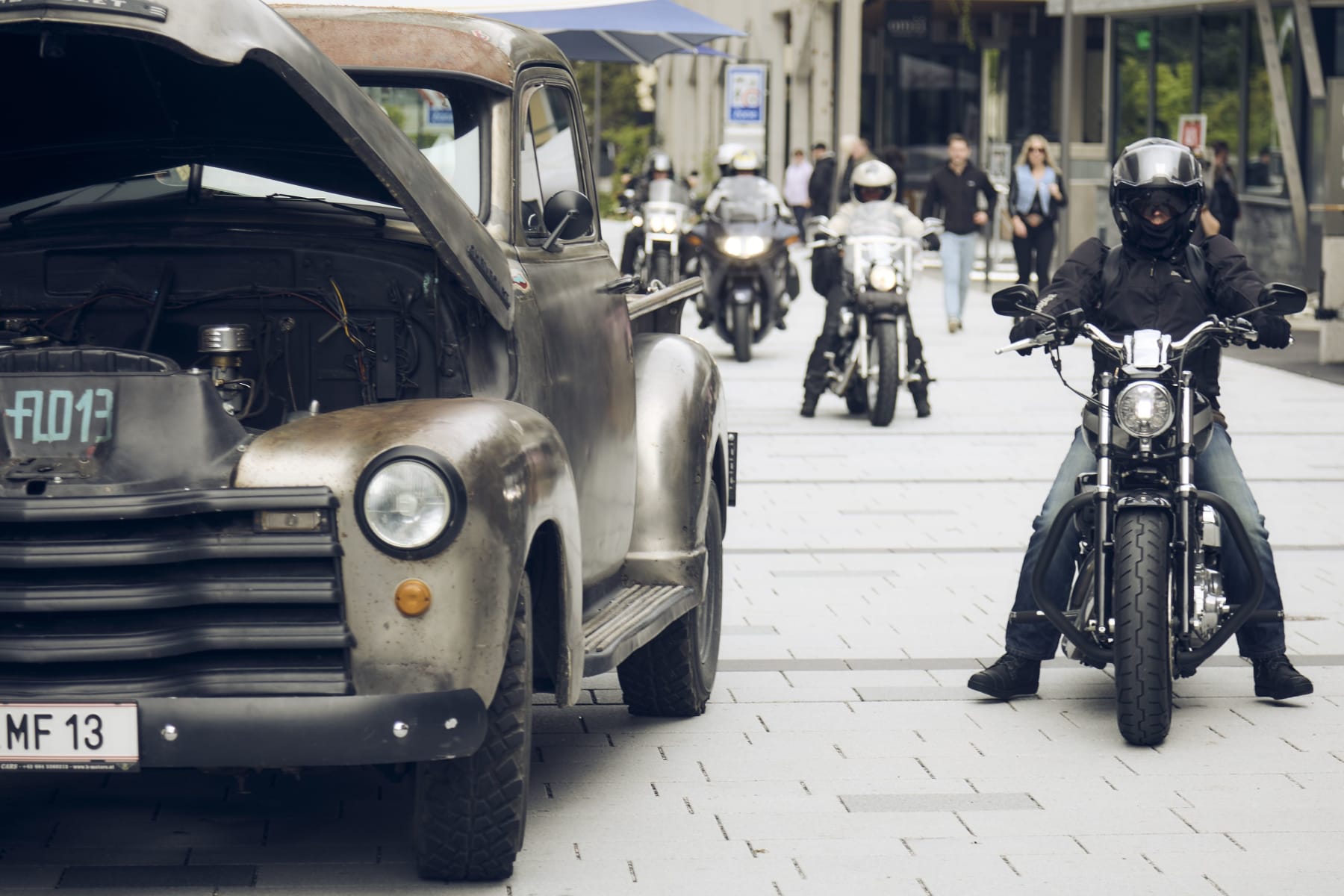 A vintage truck and motorcycles on the street in Hinterglemm.