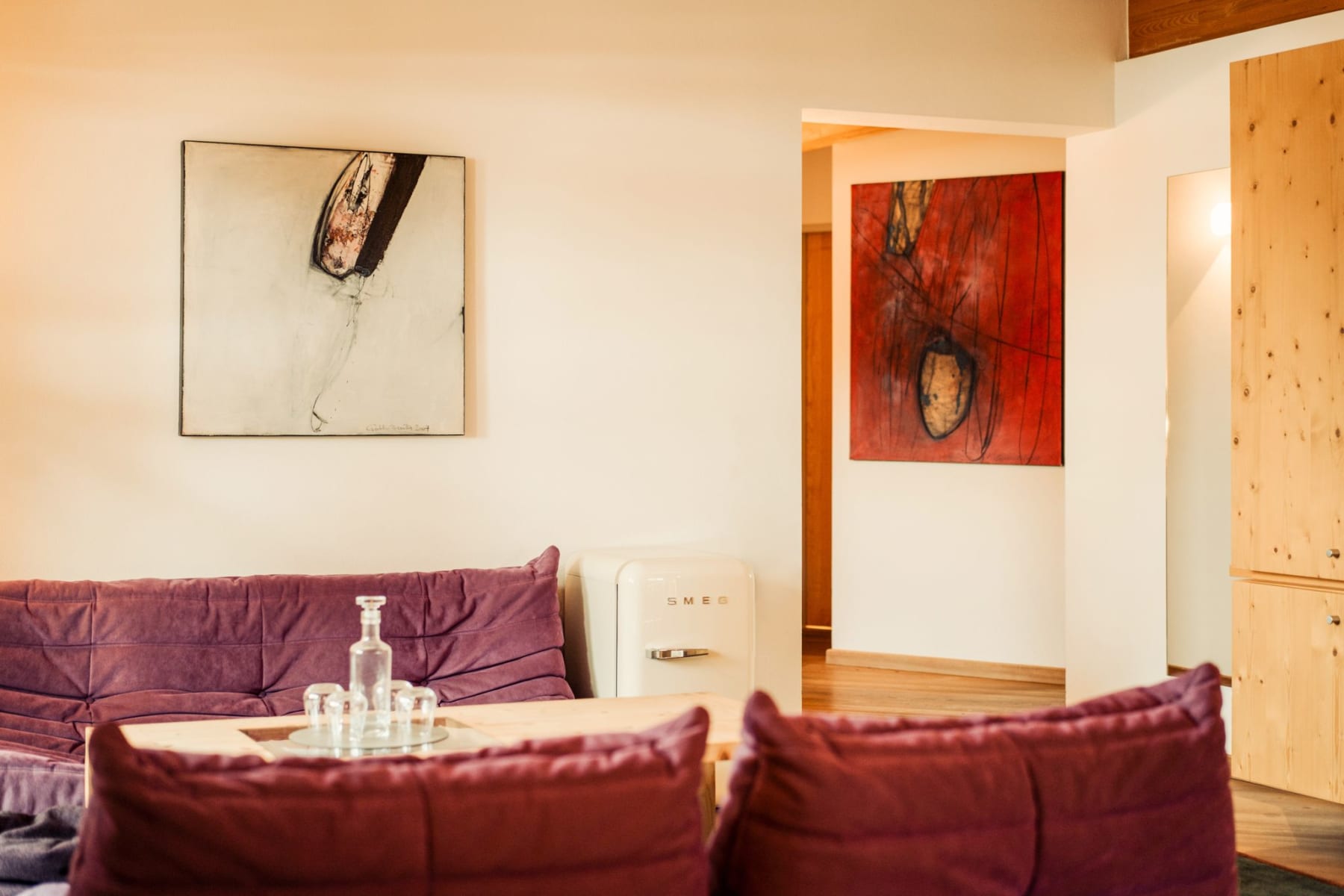 Ein moderner Innenraum mit Kunstwerken und gemütlichen Sofas im Glemmtalerhof in Hinterglemm.