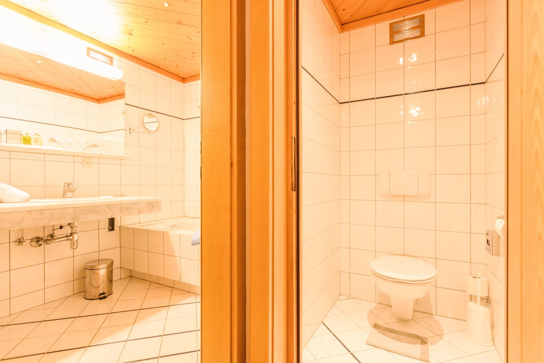 Badezimmer im Glemmtalerhof in Hinterglemm mit moderner Einrichtung und hellen Fliesen.