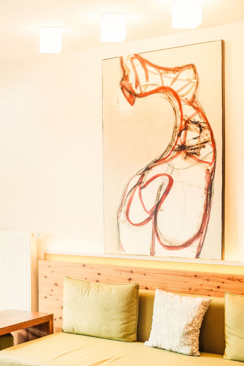 A bright room at Glemmtalerhof with a modern artwork above a cozy sofa.