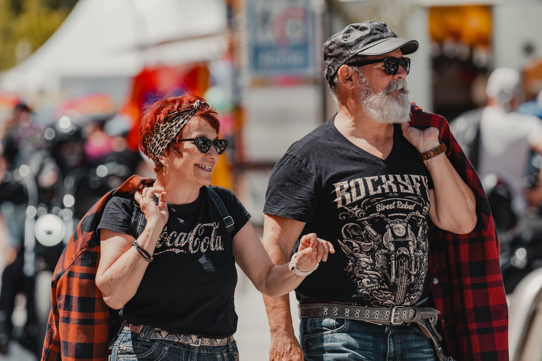 A couple walks smiling in Hinterglemm, with the Glemmtal behind.