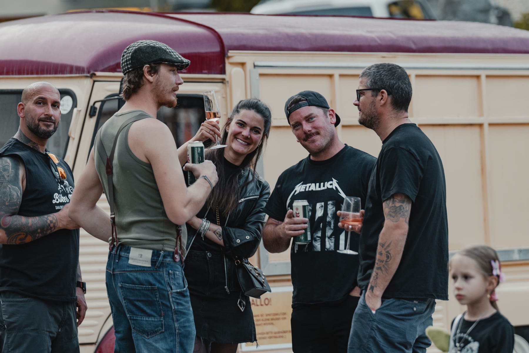 Group of friends with drinks in front of a van in Hinterglemm.