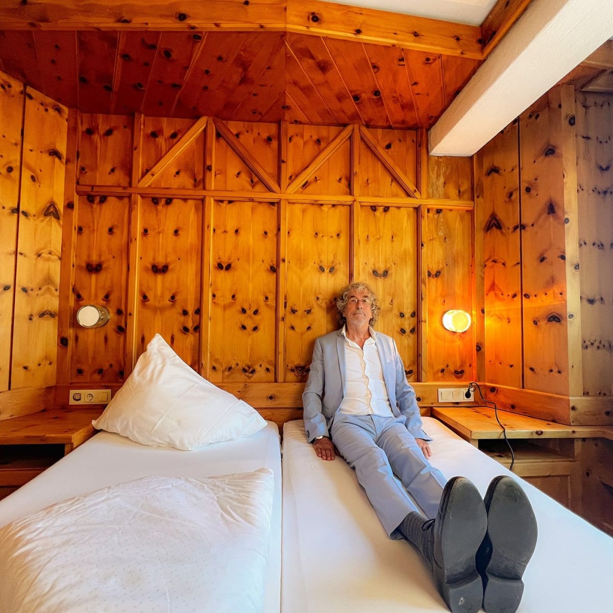 Eine Person sitzt entspannt im Zimmer des Glemmtalerhofs in Hinterglemm.