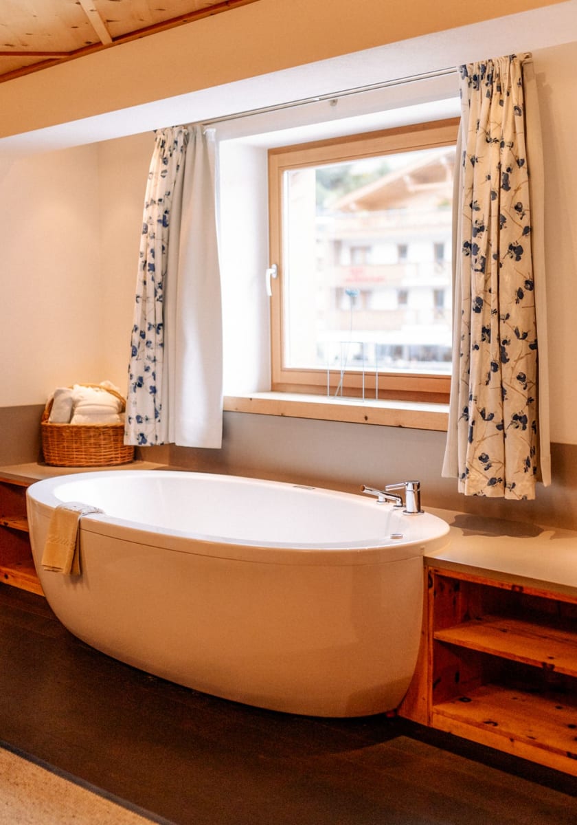 Moderner Badbereich mit freistehender Badewanne im Glemmtalerhof.