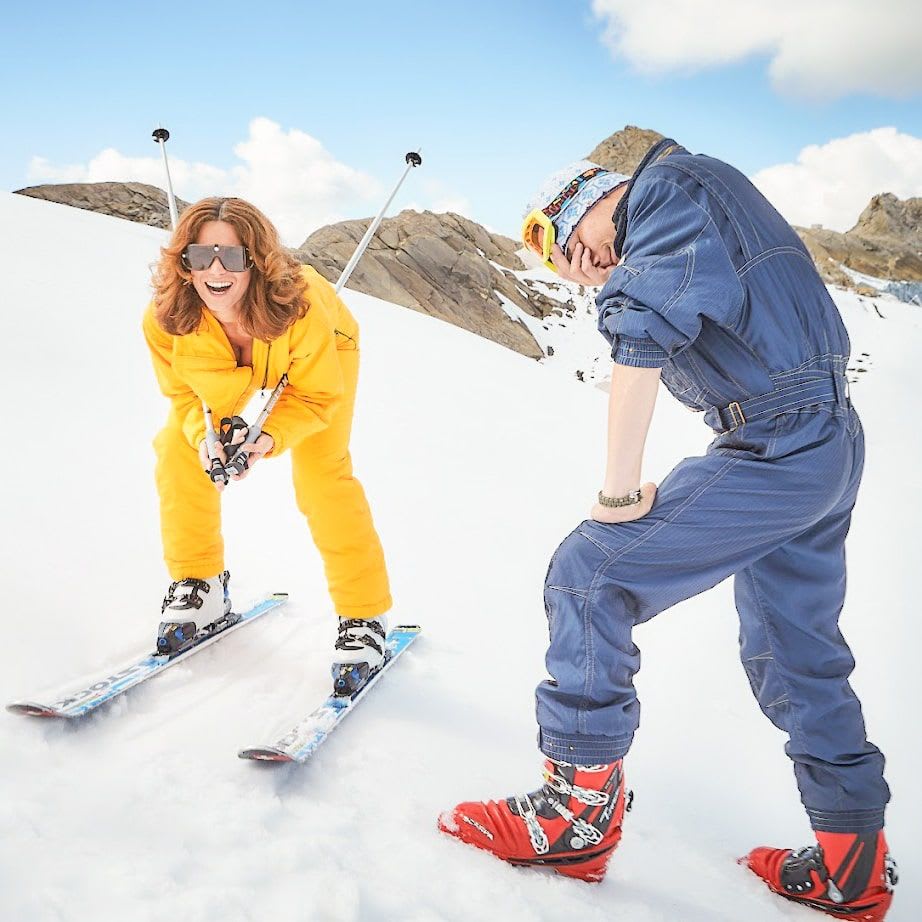 Skifahrer im Glemmtal lachen im Schnee. Ein herzliches Winterabenteuer.