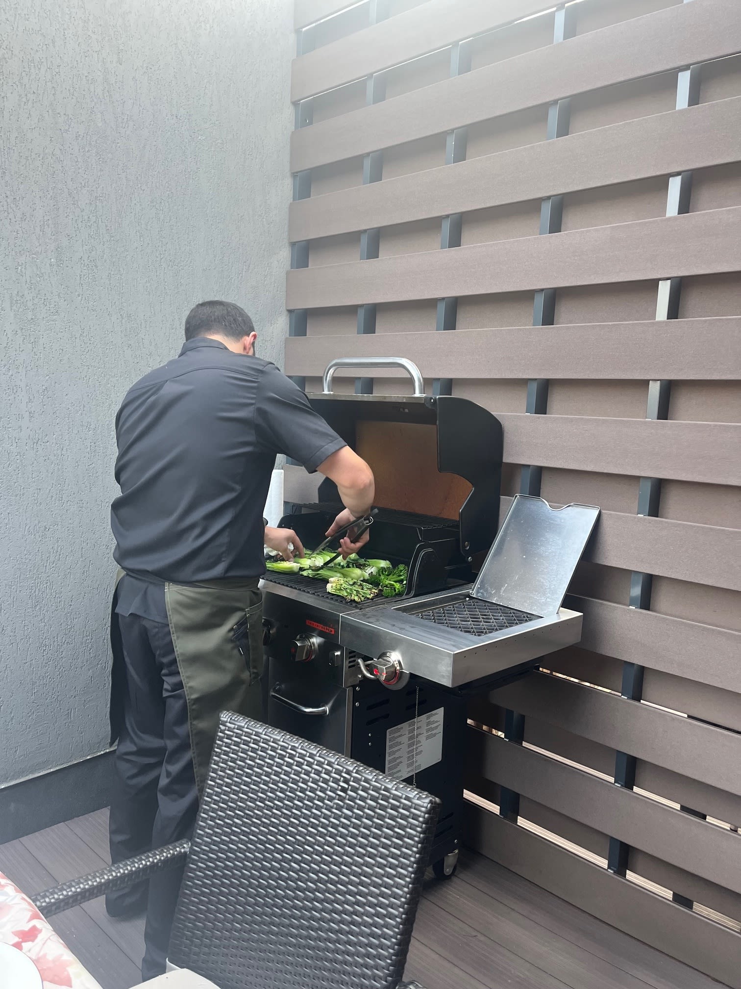 Private chef grilling fresh vegetables on an outdoor barbecue as part of a personalized dining service