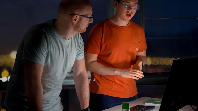 Three people in front of computer - FDTech.de