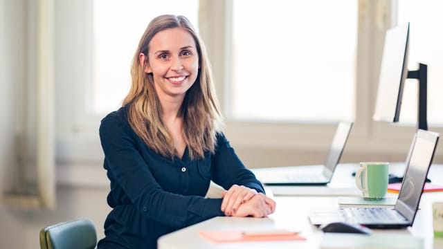 Young businesswoman smiles at camera - FDTech.de