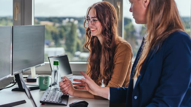 Three people in front of computer - FDTech.de