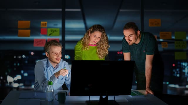 Three people in front of computer - FDTech.de