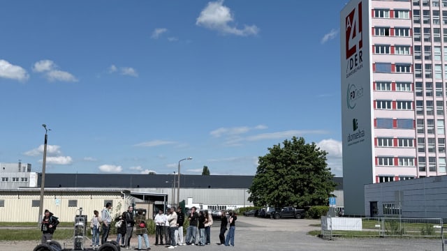 French exchange students standing in front of the PixKit autonomous vehicle in the FDTech parking lot during a live demonstration in Chemnitz.