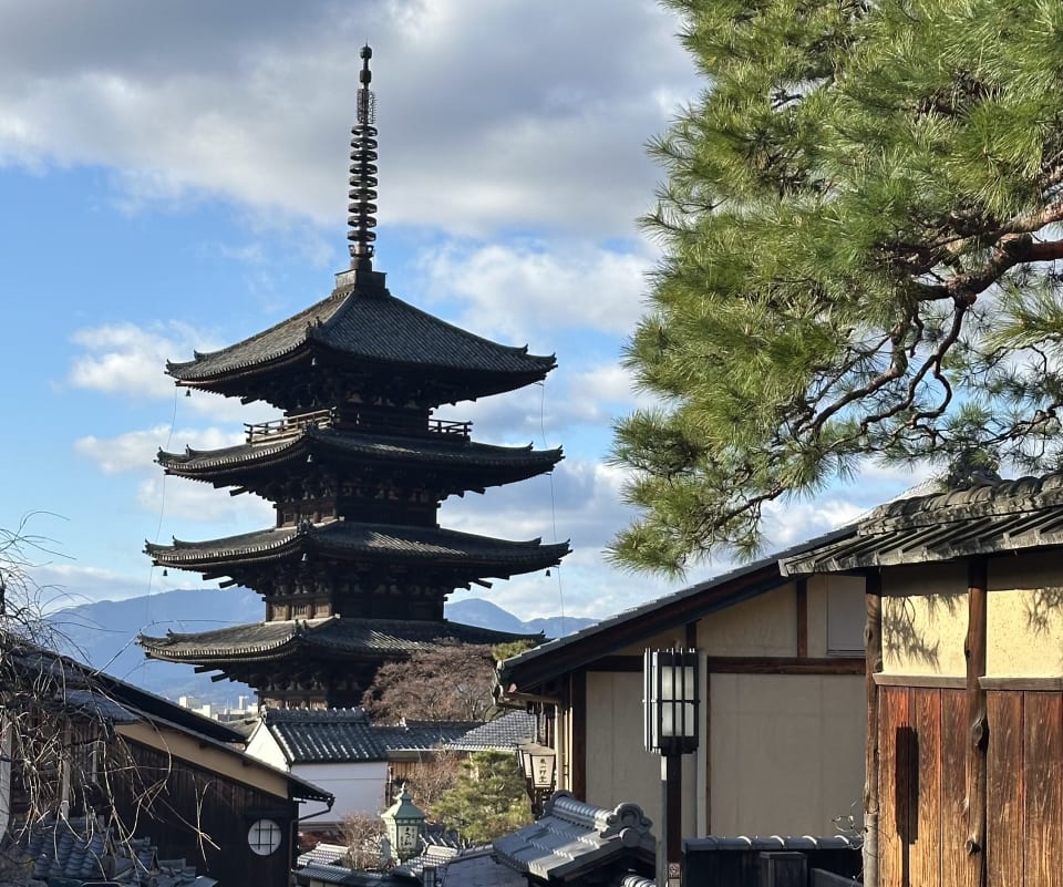 Yasaka Pagoda (Hokan-ji) rising above traditional rooftops and a pine tree in Kyoto