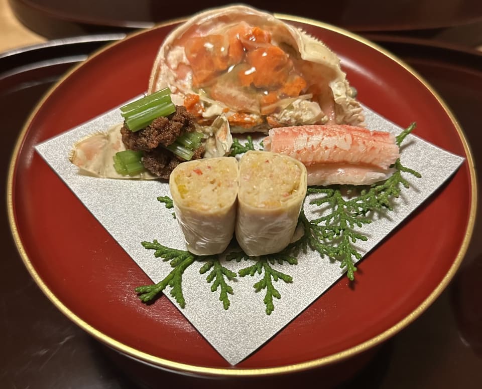Crab and rolls on silver paper in a red lacquer bowl at Kashiwaya Senriyama, Osaka