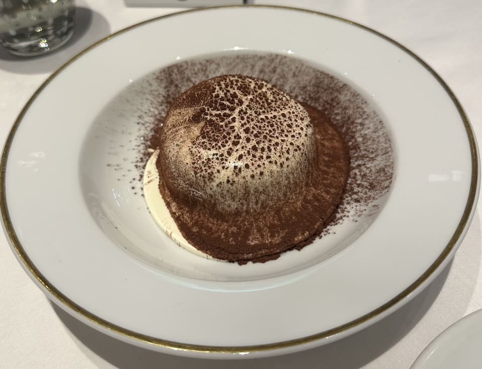 Tiramisu dusted with cocoa in a wide white bowl with gold rim at Langosteria Bistrot, Milan