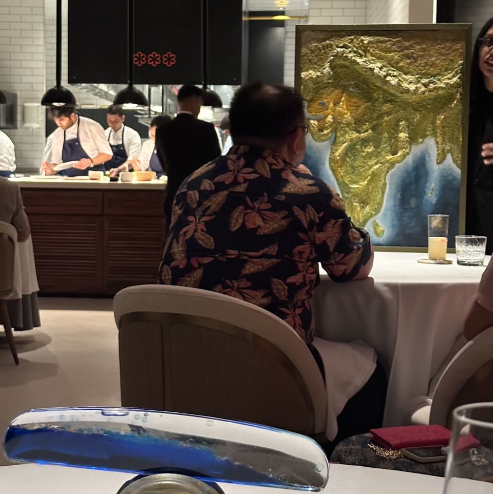 Tresind Studio dining room: open kitchen with chefs, map of India on a guest table, and decor
