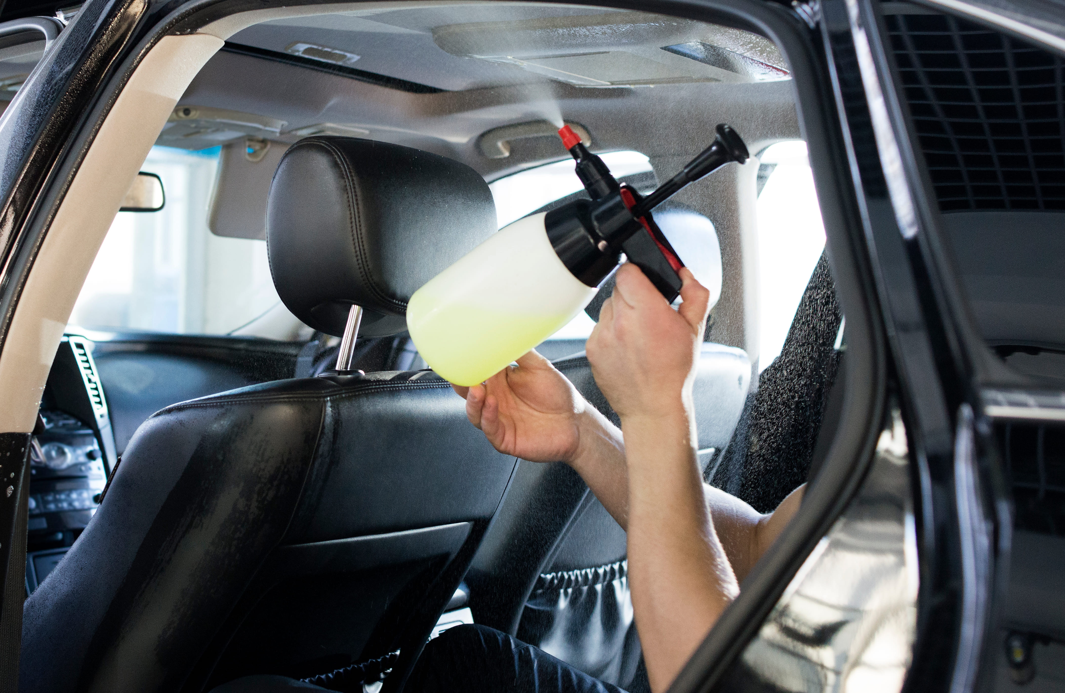 Hombre limpiando el techo de un carro