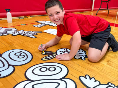 Parade photo of kids with a giant Doodle character