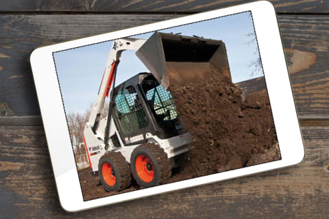 Bobcat Skid-Steer Loader  Dumping Dirt into a Pile with Operator Inside the Cab