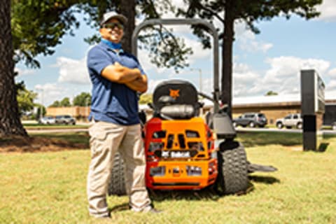 Junior Santos next to Bobcat zero-turn mower in field